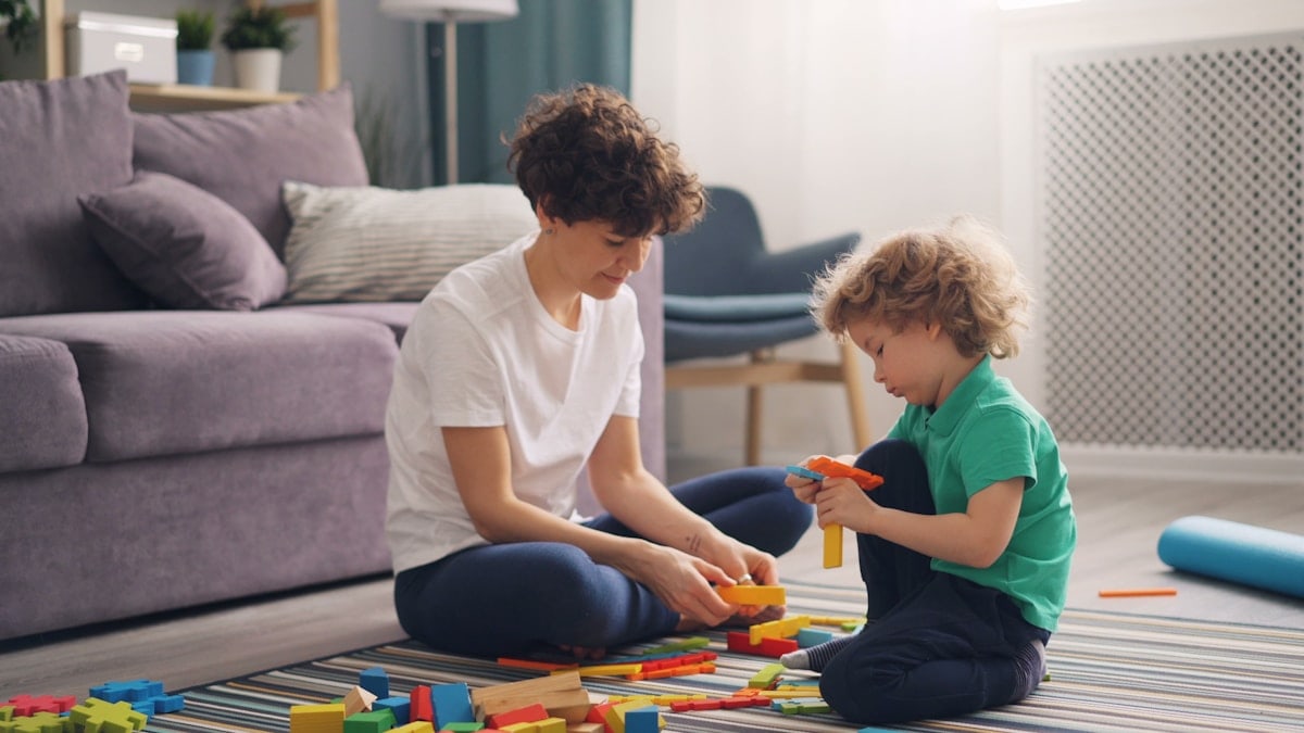 a man and a child playing with blocks on the floor